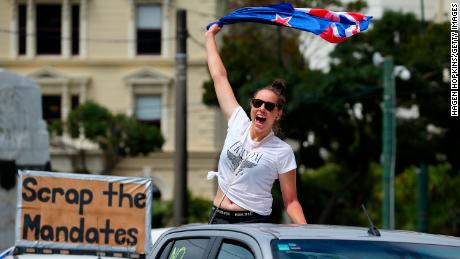 Un manifestant agite un drapeau derrière une voiture à Wellington mardi.