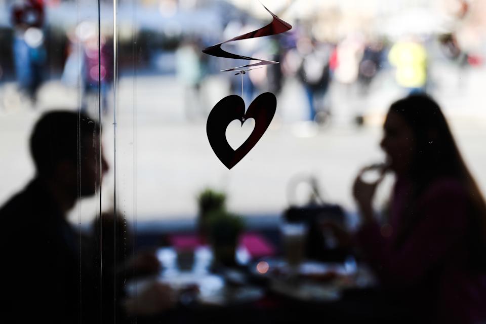 Décoration en forme de cœur et un couple assis à table dans le restaurant, la veille de la Saint-Valentin, à Cracovie, en Pologne, le 13 février 2022 (Photo de Jacob Borzeki/Noor Photo via Getty Images)